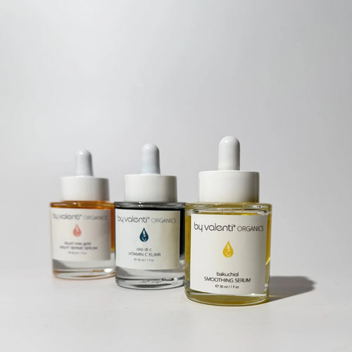 Three By Valenti skincare serum bottles from on a light gray background