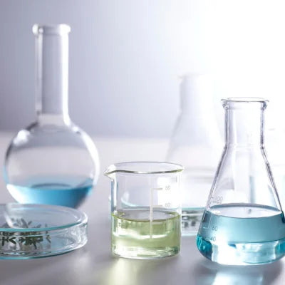 Laboratory glassware with different colored liquids on a light background