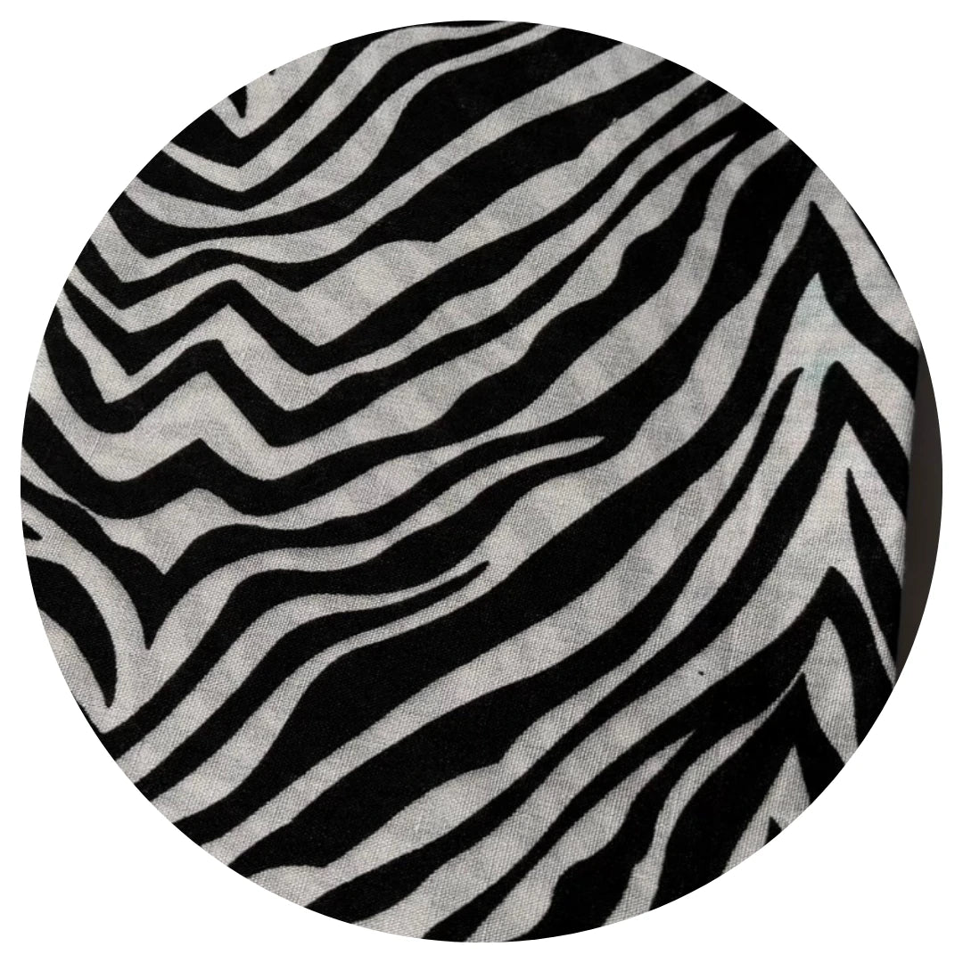 Round rug with black and white zebra stripe pattern on a white background