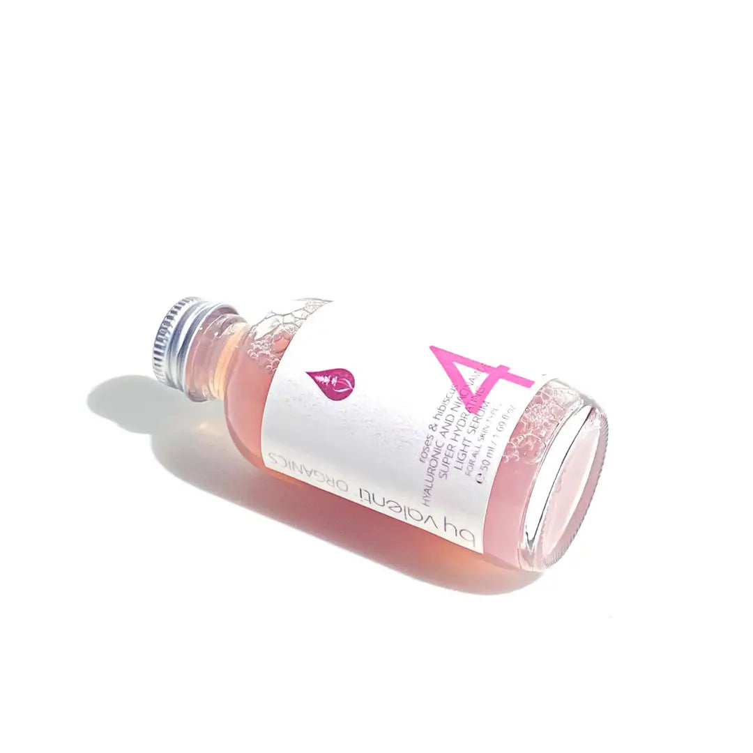 Bottle of By Valenti skincare product with a white label and pink accents on a white background