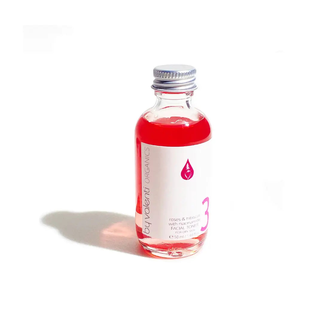 By Valenti Italian skincare small bottle of face serum with red liquid and a white label on a white background