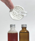 By Valenti double cleansing set displaying two bottles of products and a reusable cotton pad with brand label 'By Valenti' on a white background