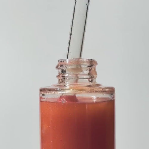 Glass bottle of By Valenti Estate a Barcola Shimmering Body Oil dripping from the dropper