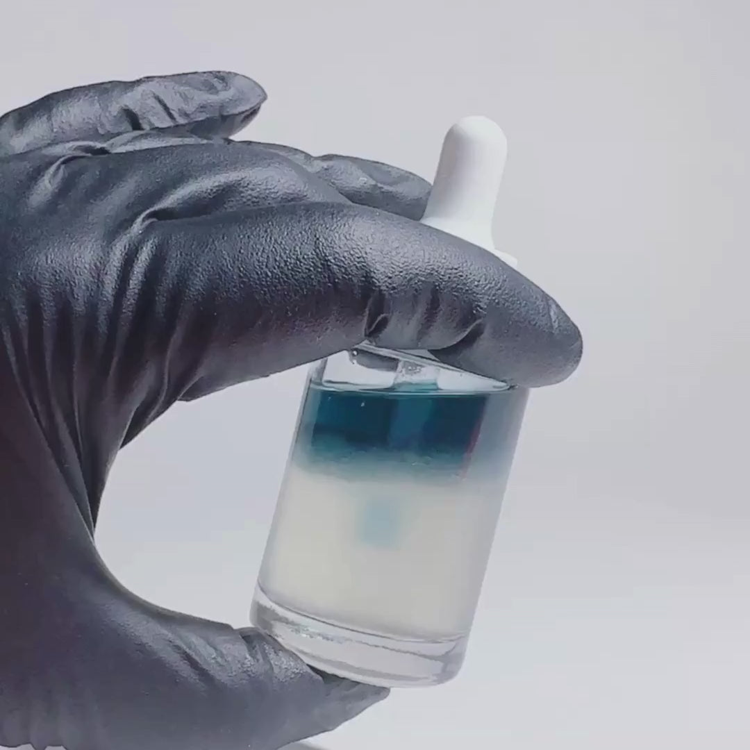 Video of hand with a black glove holding a By Valenti biphase blue and clear serum